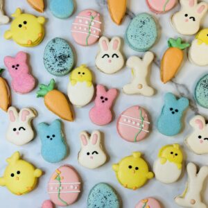 Colorful Easter-themed cookies on marble surface.